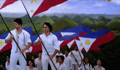 A Group Of People Holding Flags With A Mountain In The Background GIF