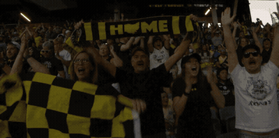 A Group Of People Holding Up A Scarf That Says " Home " GIF