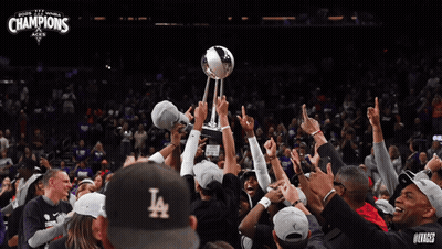 A Group Of People Holding Up A Trophy With The Word Champions On It GIF