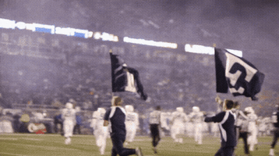 A Group Of People Holding Up Flags With The Number 5 On Them GIF