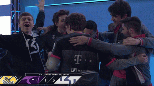 A Group Of People Hugging Each Other With A Scoreboard That Says Sk Gaming Win Swc 2019 GIF