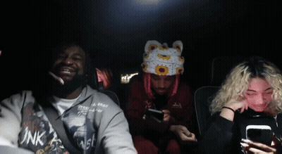 A Group Of People In A Car With One Wearing A Pink Shirt That Says Ink GIF