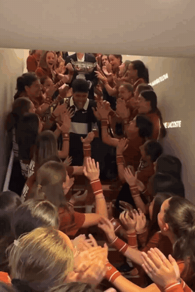 A Group Of People In A Hallway With The Word Lacoste Written On The Wall GIF