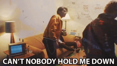 A Group Of People In A Living Room With The Words Can 'T Nobody Hold Me Down Written On The Bottom GIF