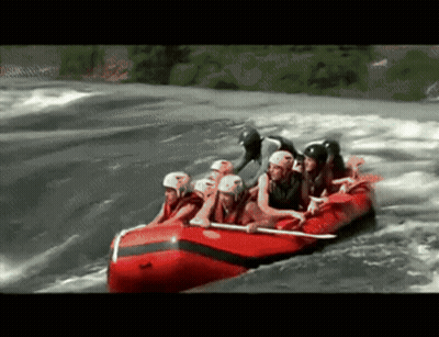 A Group Of People In A Red Raft Going Through A River GIF