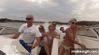A Group Of People In Bikinis Are Riding A Boat In The Water . GIF