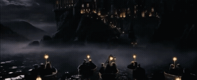 A Group Of People In Boats With Lanterns In The Water In Front Of A Castle GIF