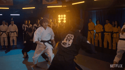 A Group Of People In Karate Uniforms Are Practicing In A Dark Room With Netflix Written On The Bottom Of The Screen GIF