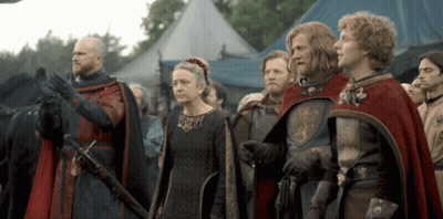 A Group Of People In Medieval Costumes Stand In Front Of A Blue Tent GIF