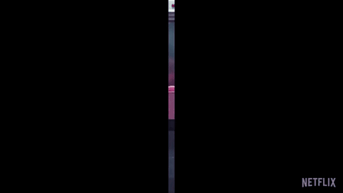 A Group Of People In Pink Jumpsuits Are Carrying A Coffin With The Netflix Logo On The Bottom GIF