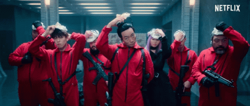A Group Of People In Red Jumpsuits With Guns And A Netflix Logo In The Corner GIF