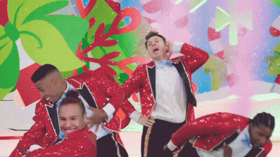 A Group Of People In Red Sequined Suits Are Dancing GIF