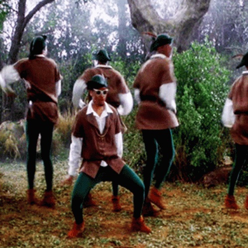 A Group Of People In Robin Hood Costumes Are Dancing GIF