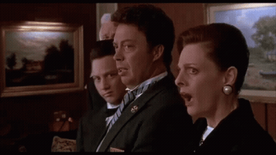 A Group Of People In Suits And Bow Ties Are Standing Next To Each Other In A Room With Their Mouths Open . GIF