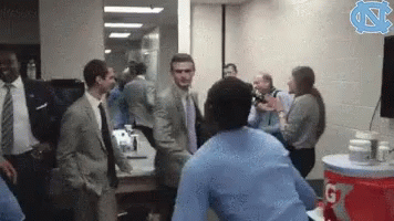 A Group Of People In Suits And Ties Are Standing Around A Gatorade Cooler GIF