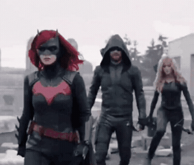 A Group Of People In Superhero Costumes Are Walking In A Line GIF