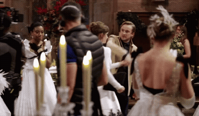 A Group Of People In White Dresses Are Standing In A Room With Candles . GIF