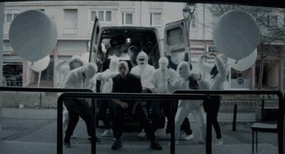 A Group Of People In White Masks Are Dancing In Front Of A White Van GIF