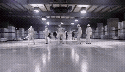 A Group Of People In White Uniforms Are Standing On A Ice Rink GIF