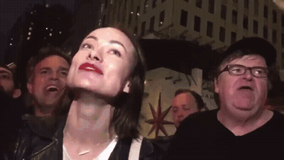 A Group Of People Including A Man With Glasses And A Woman With Red Lips GIF