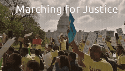 A Group Of People Marching For Justice With A Capitol Building In The Background GIF
