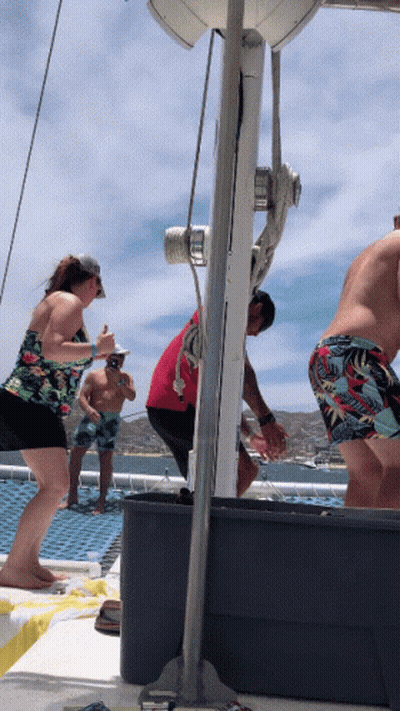 A Group Of People On A Boat Including A Man In A Red Shirt And A Woman In A Floral Top GIF