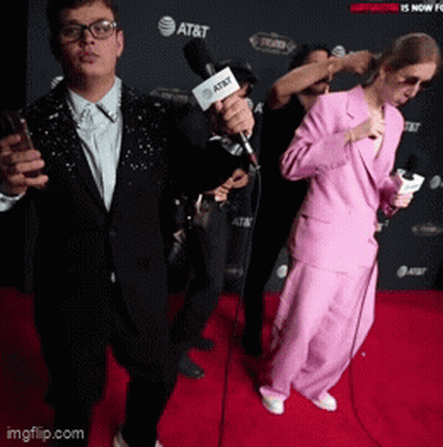 A Group Of People On A Red Carpet With At & T In The Background GIF
