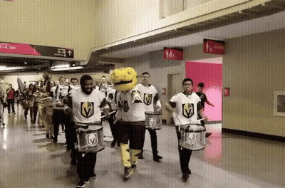 A Group Of People Playing Drums In A Hallway With A Sign That Says Men 'S And Women 'S Restrooms GIF