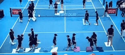 A Group Of People Playing Tennis On A Blue Court With Emirates Advertisements GIF