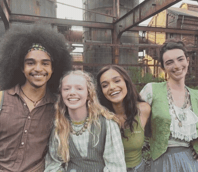 A Group Of People Posing For A Picture With One Of Them Wearing A Green Vest GIF