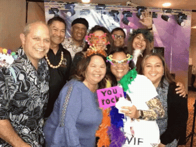 A Group Of People Posing For A Picture With One Woman Holding A Sign That Says " You Rock " GIF