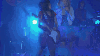 A Group Of People Singing In Front Of A Sign That Says " Determine " GIF
