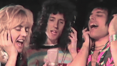 A Group Of People Singing Into A Microphone With Headphones GIF