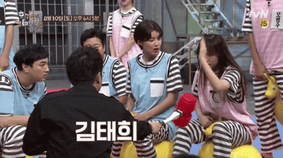 A Group Of People Sitting Around A Man With A Sign That Says Vnn 15 On It GIF