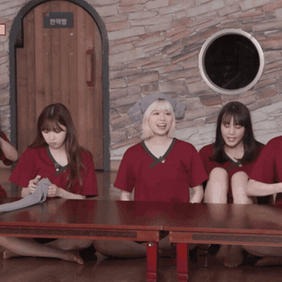 A Group Of People Sitting Around A Table With A Sign On The Wall That Says ' A ' On It GIF