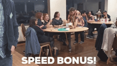 A Group Of People Sitting Around A Table With The Words Speed Bonus Written In White GIF