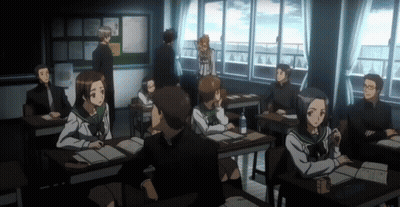 A Group Of People Sitting At Desks In A Classroom With A Bulletin Board In The Background GIF