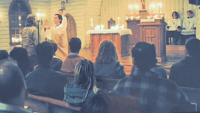 A Group Of People Sitting In A Church Watching A Priest GIF