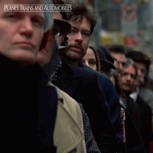 A Group Of People Sitting In A Line With The Words Planes Trains And Automobiles On The Bottom Right GIF