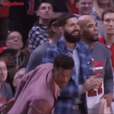 A Group Of People Sitting In A Stadium Watching A Basketball Game GIF