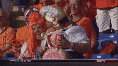 A Group Of People Sitting In A Stadium Watching A Game With A Coca Cola Can In Their Hand GIF