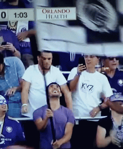 A Group Of People Sitting In A Stadium With A Sign That Says Orlando Health On It GIF