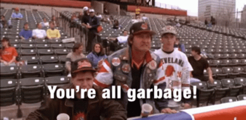 A Group Of People Sitting In A Stadium With The Words " You 'Re All Garbage " On The Screen GIF