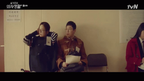 A Group Of People Sitting In Front Of A Sign That Says Tvn On It GIF