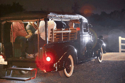 A Group Of People Sitting In The Back Of A Truck GIF