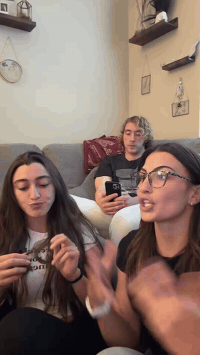 A Group Of People Sitting On A Couch One Of Whom Is Wearing A Shirt That Says " I Love You " GIF