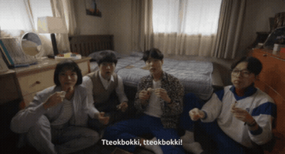 A Group Of People Sitting On The Floor With Tteokbokki Written On The Bottom Right GIF