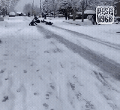 A Group Of People Sledding Down A Snow Covered Street With The Year 1968 On The Bottom GIF