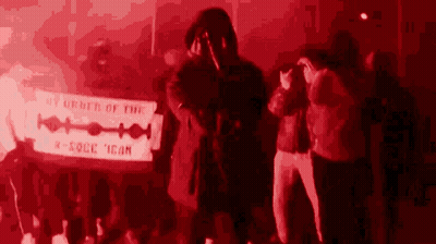 A Group Of People Standing Around A Sign That Says By Order Of The K-Rock Icon GIF
