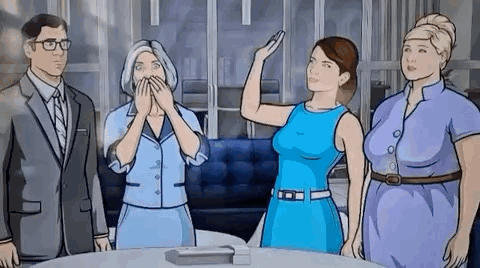 A Group Of People Standing Around A Table With A Woman Holding A Remote Control . GIF